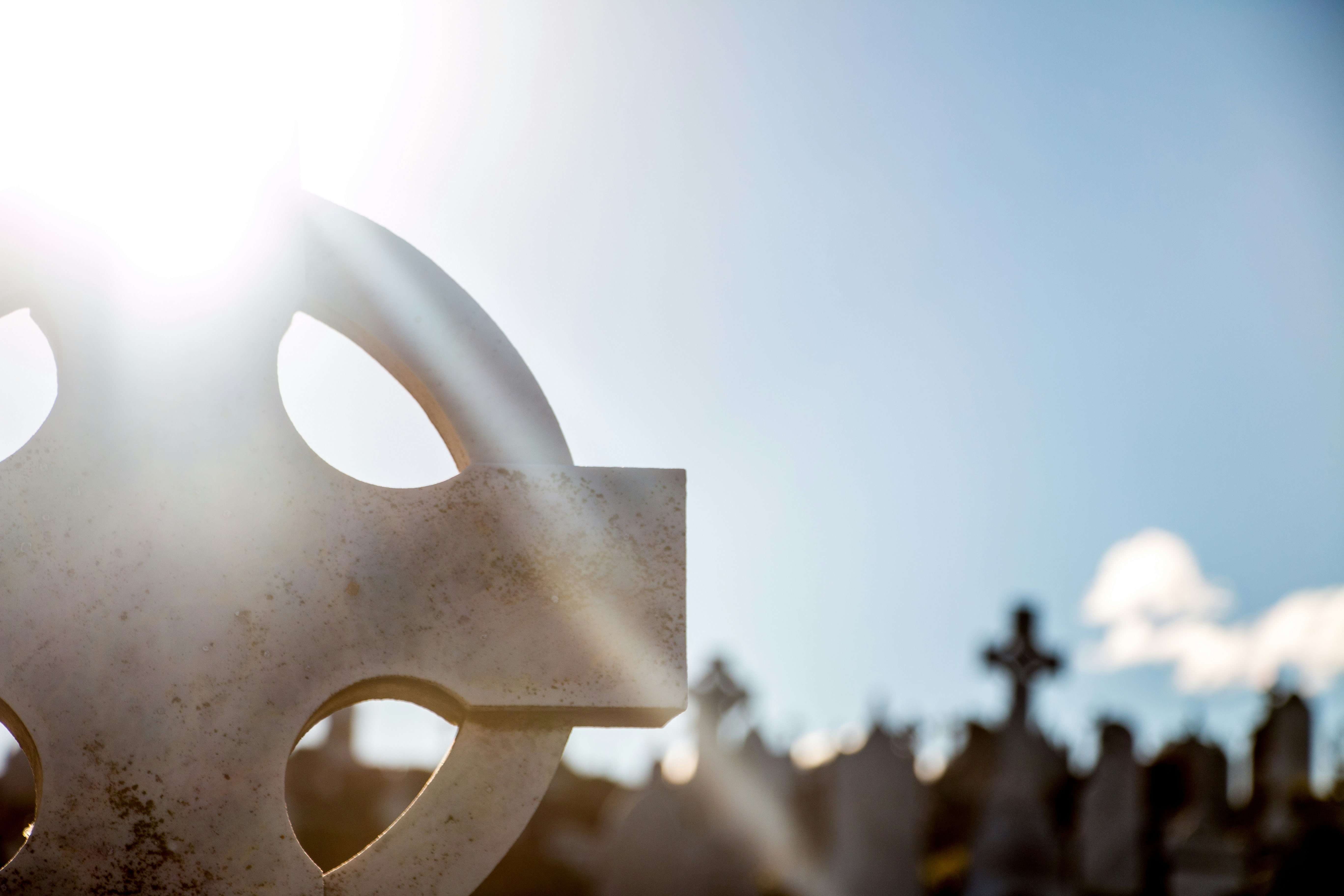selective focus photography of gray tombstone cross